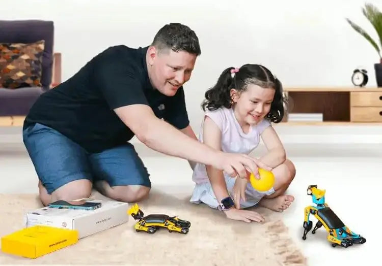 A dad and his daughter play with Petoi Bittle open source and programmable robot dogs.